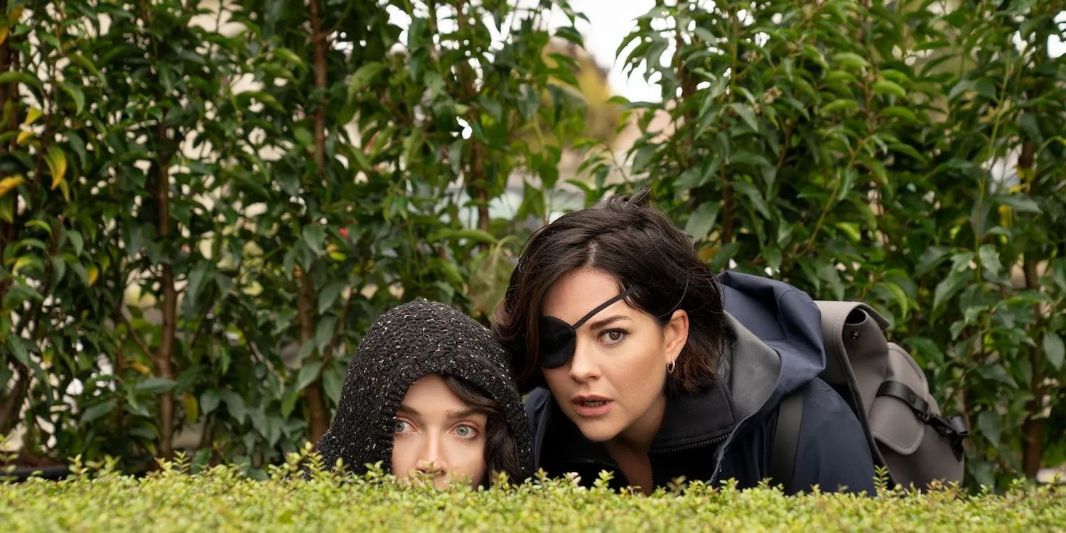 Becka (Eve Hewson) y Bibi (Sarah Greene) miran sobre los setos verdes sospechosamente.