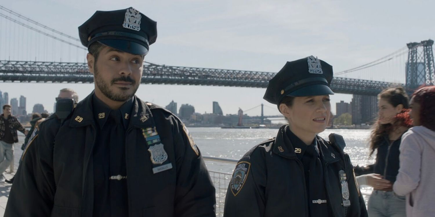 Officers Luis (Ian Quinlan) and Eddie (Vanessa Ray) walk by the Brooklyn Bridge.