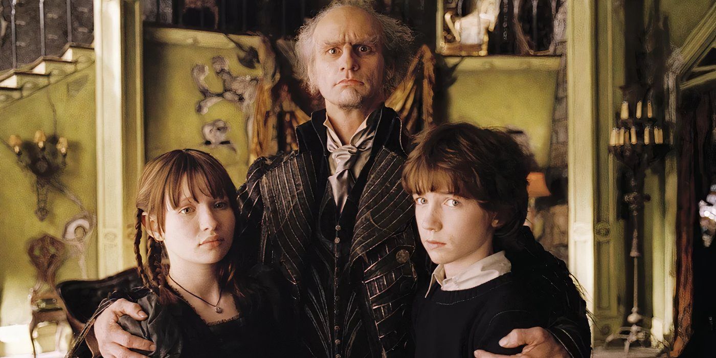 Count Olaf puts his arms around Violet and Klaus in the Lemony Snicket movie.