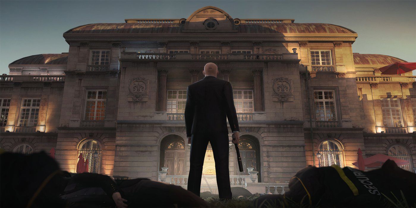 Agente 47 em pé em frente a uma mansão em Hitman 3