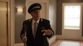 Teddy trying to talk to someone, his hand out, in the lobby of the Arconia on Only Murders in the Building.