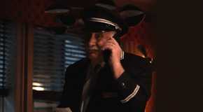 Lester from Only Murders in the Building in an apartment on the phone in the dark.