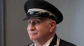 A side profile of Teddy smiling in Only Murders in the Building.