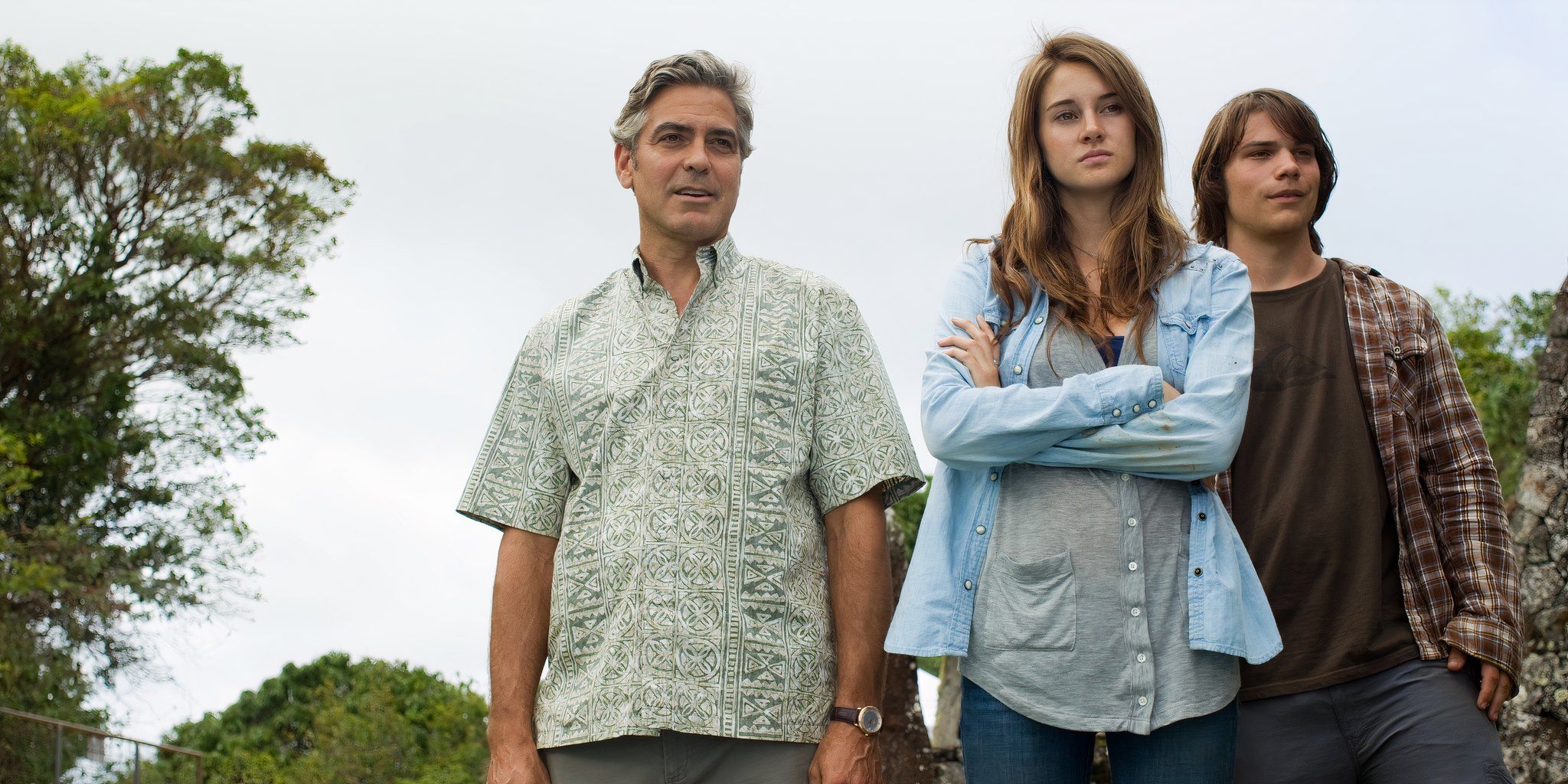 Matt, Alex, and Sid are standing together on a hill in Hawaii in The Descendants