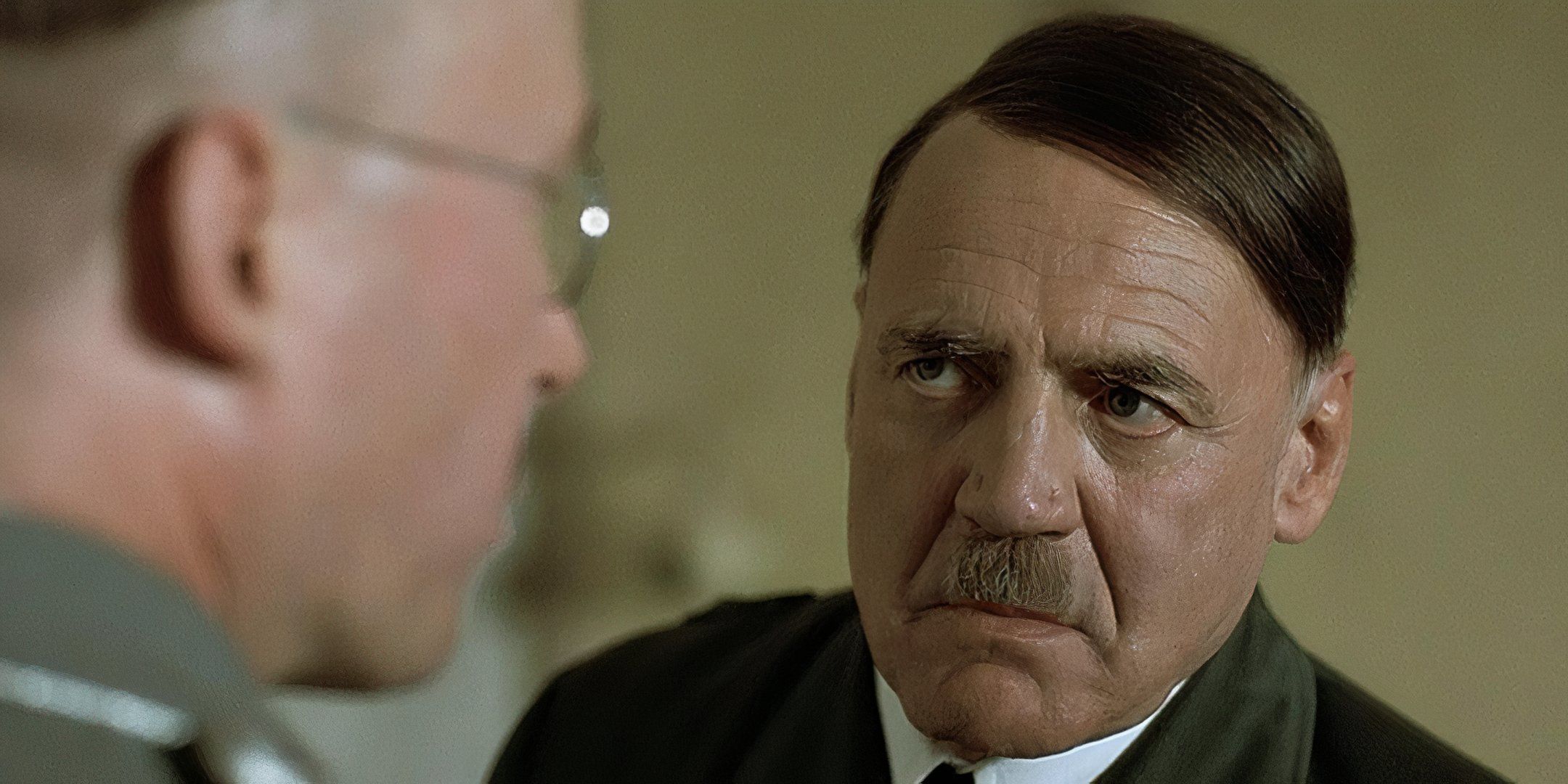 Bruno Ganz luciendo severo durante una conversación como Adolf Hitler en Downfall.