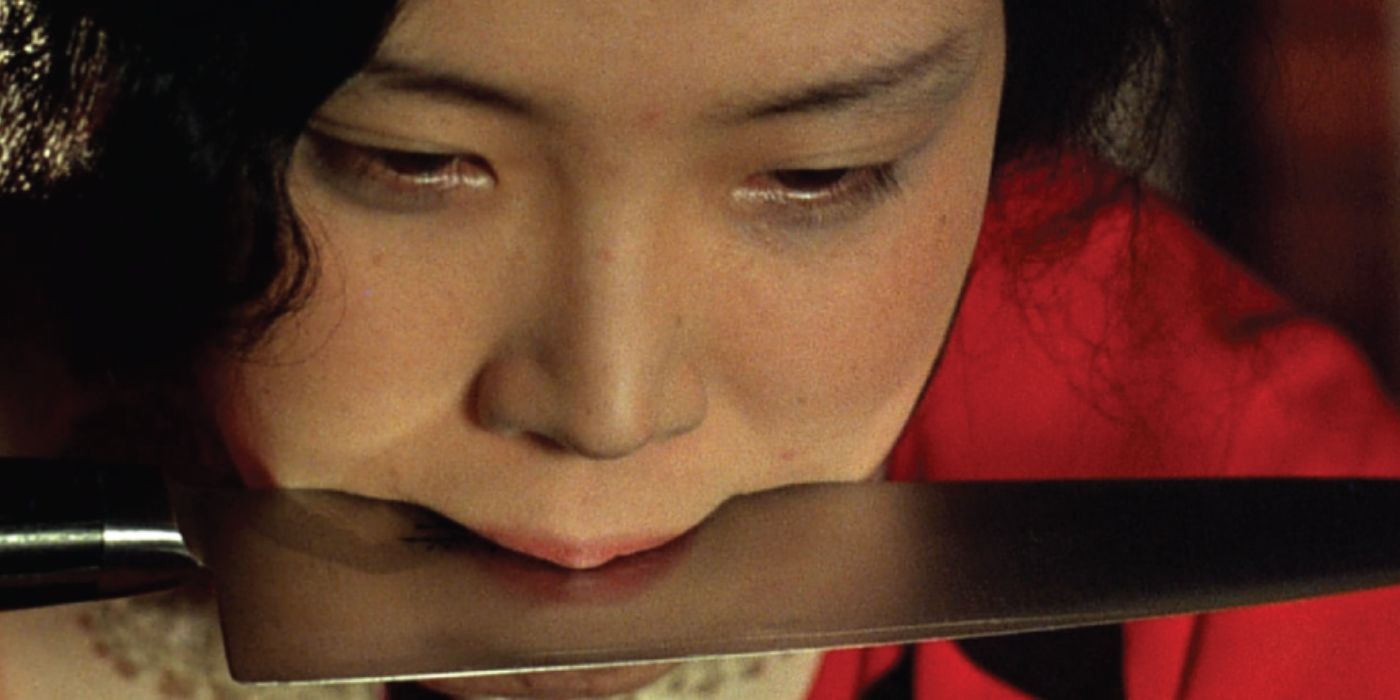 Sada Abe holding a knife in her mouth in The Realm of the Senses