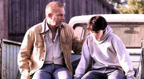 Kevin Costner as Jonathan Kent sitting on a truck bed arm around young Clark from Man of Steel