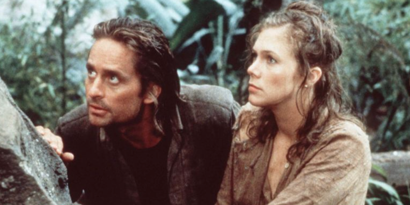 Jack e Joan se escondem atrás de uma pedra na selva em Romancing the Stone.