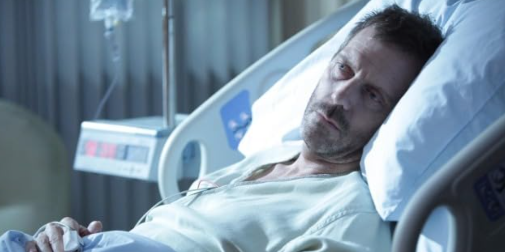 Dr. House está deitado em uma cama de hospital em House MD.