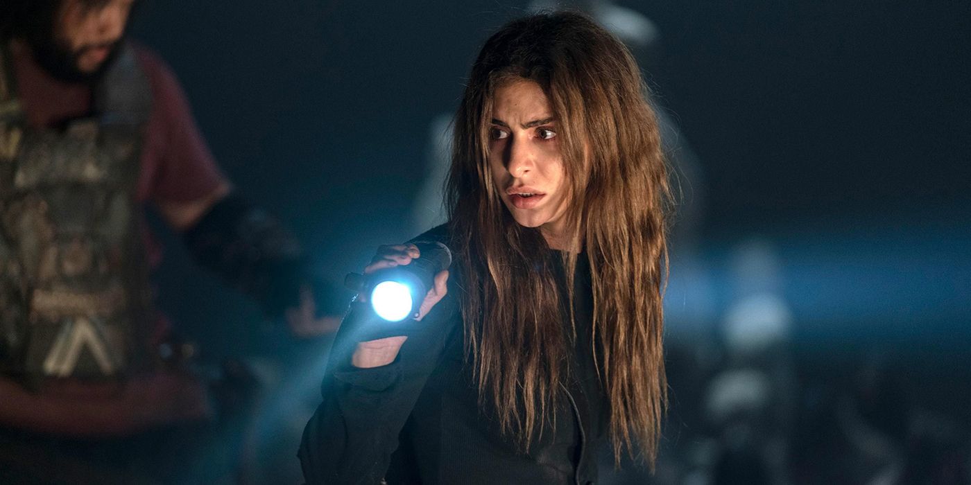 Magna in the dark holding a flashlight in The Walking Dead.