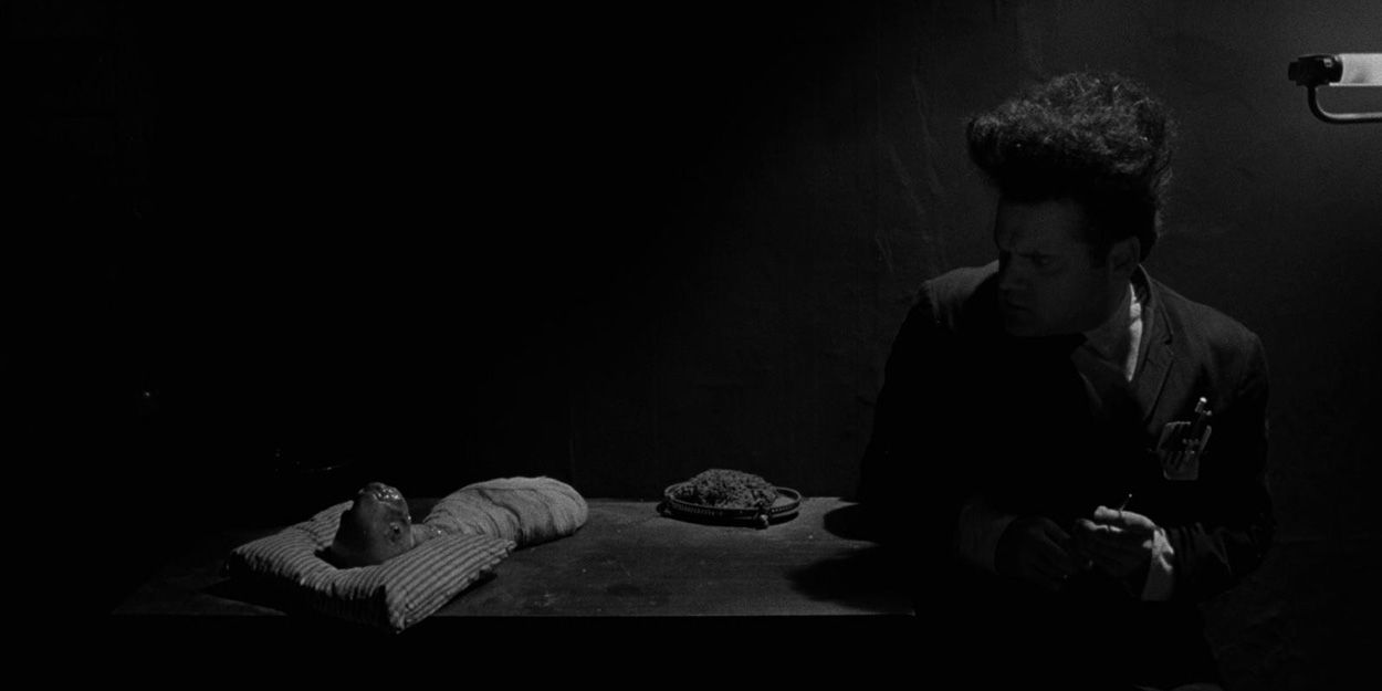 Henry Spencer (Jack Nance) olha para seu bebê deformado em Eraserhead.