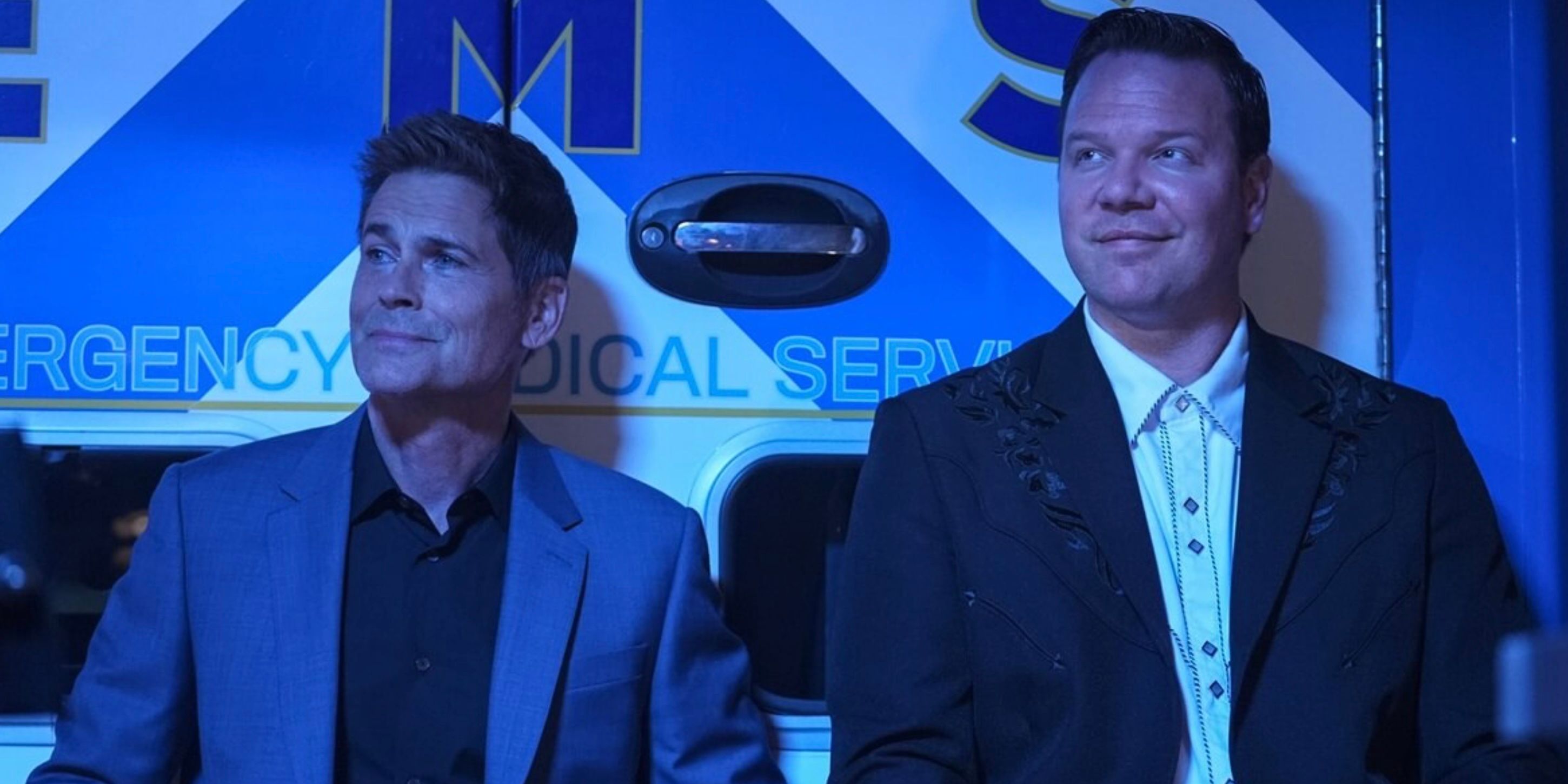 Owen (Rob Lowe) and Judd (Jim Parrack) sitting against an ambulance wearing suits on 9-1-1 Lone Star