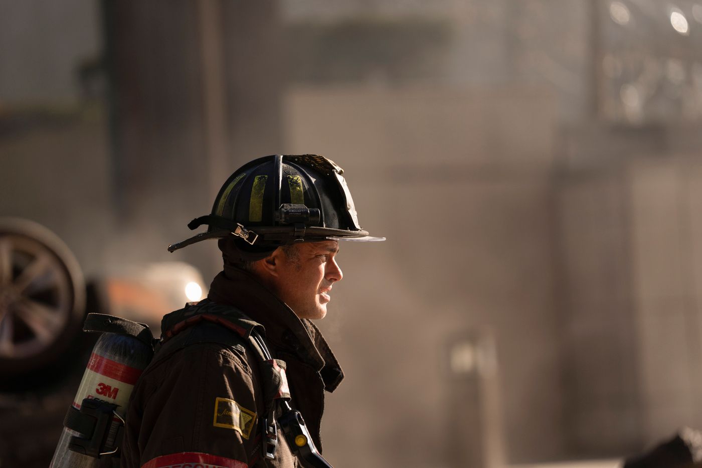 Kelly Severide, played by Taylor Kinney, seen in profile wearing firefighter gear on Chicago Fire