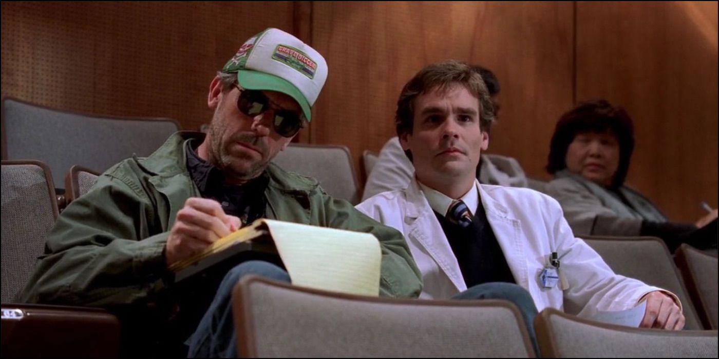 Dr. House y Wilson sentados en una conferencia