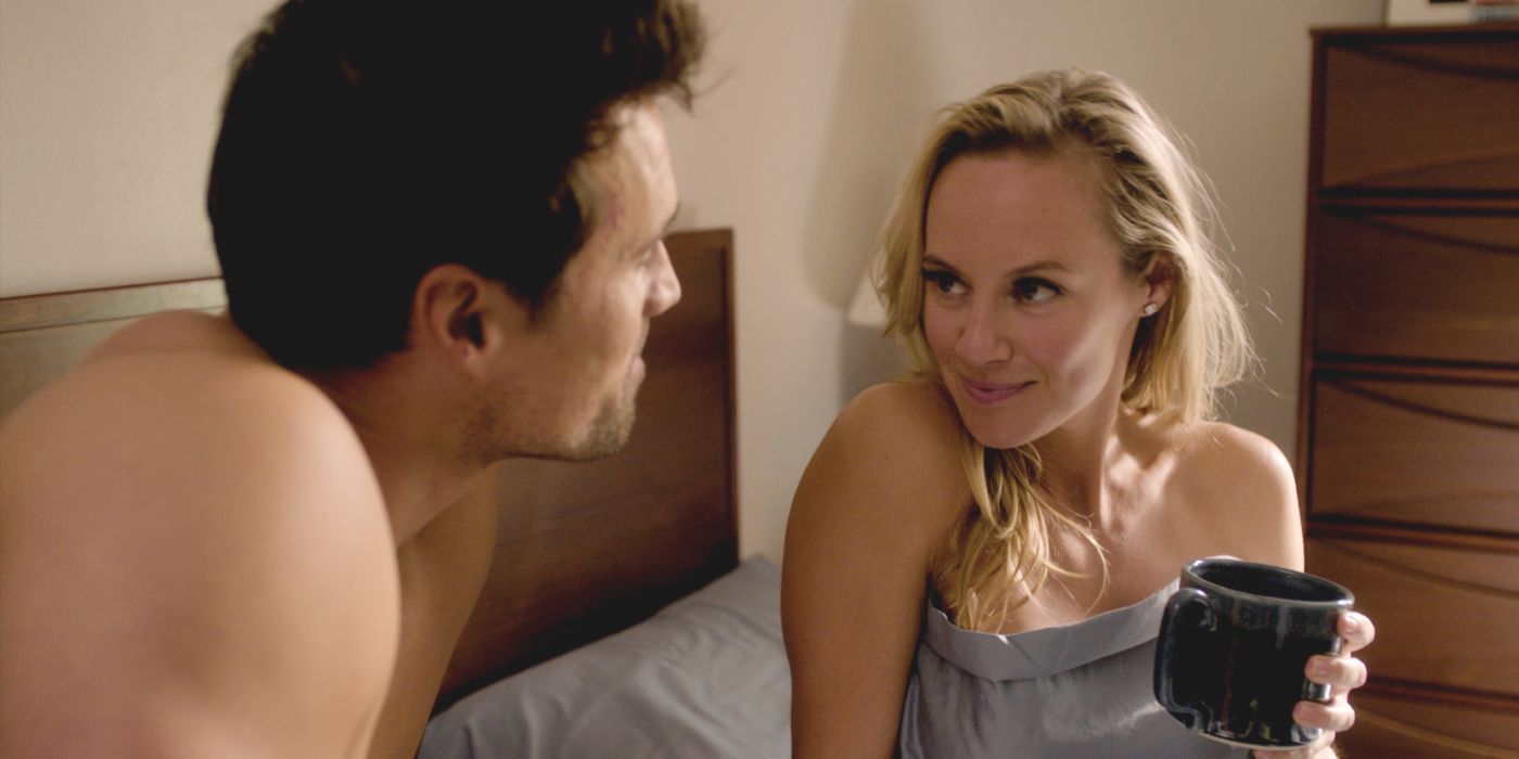 Heather (Danielle Savre) sostiene una taza de café mientras está sentada en la cama con Mark (Brett Dalton) en Found