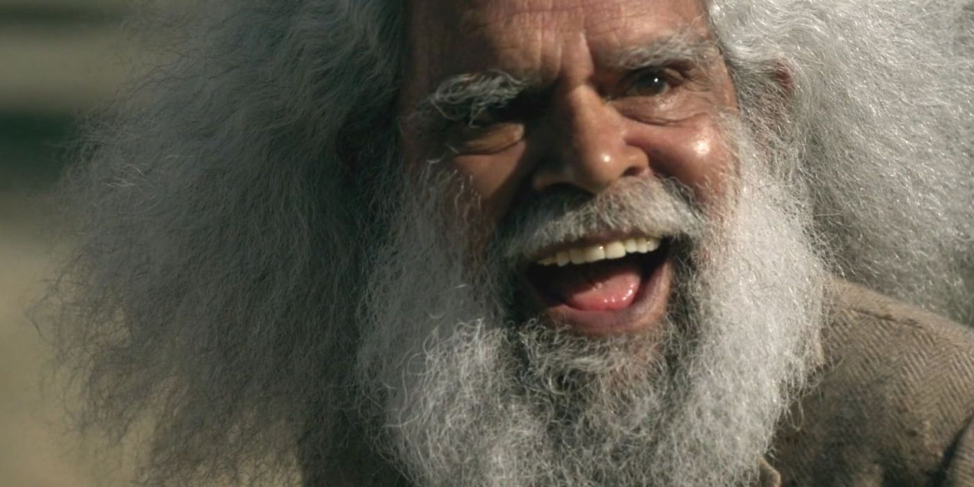 Jack Charles como Old Boy sorri com cabelo e barba grandes em Mystery Road