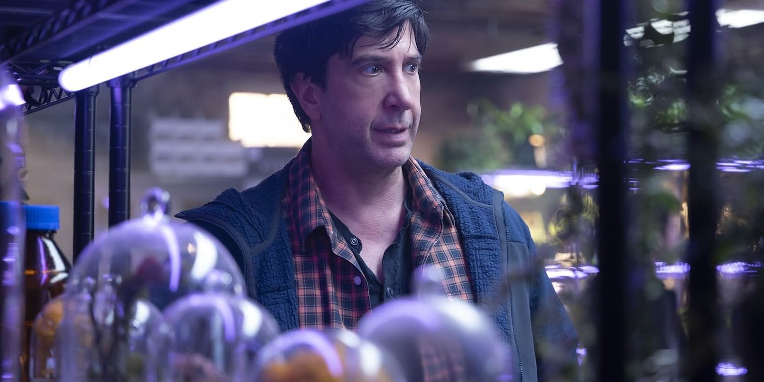 Anthony (David Schwimmer) está cercado por espécimes de plantas em redomas de vidro na 2ª temporada de Goosebumps