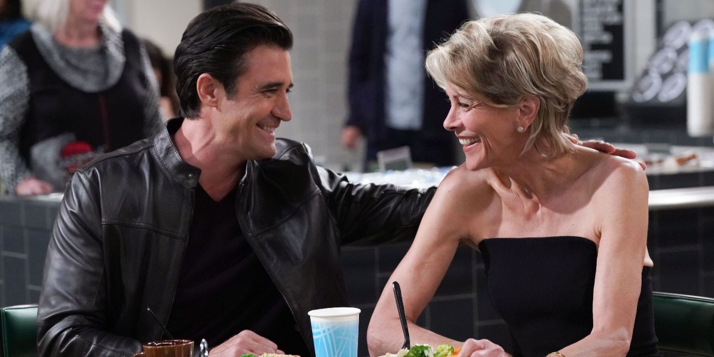 Rodrigo (Gilles Marini) laughs with Julianne (Wendie Malick) as they sit at a table in Night Court