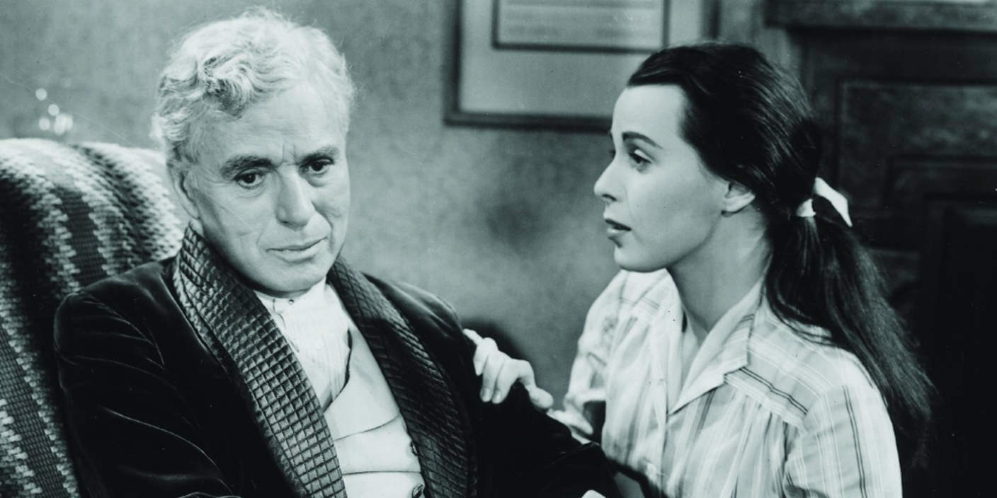 Claire Bloom se ajoelha ao lado de Chaplin (sentado) com as mãos em seu ombro em Limelight.