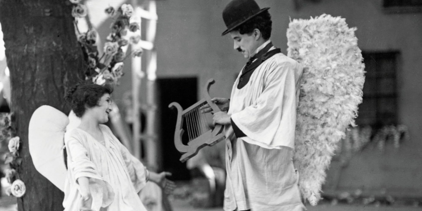 Charlie Chaplin e uma mulher estão vestidos de anjos em The Kid.