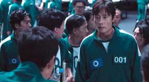 Player 001 approaches Gi-hun in a crowd of players.