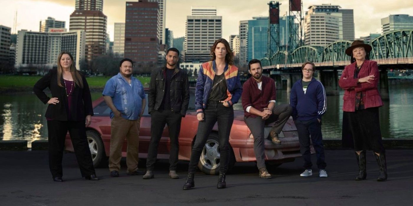 O elenco de Stumptown, alguns dos quais incluem Dex Parios (Cobie Smulders), Gray McConnell (Jake Johnson) e o Tenente Cosgrove (Camryn Manheim), estão parados na frente de um carro estacionado em frente ao rio Willamette.