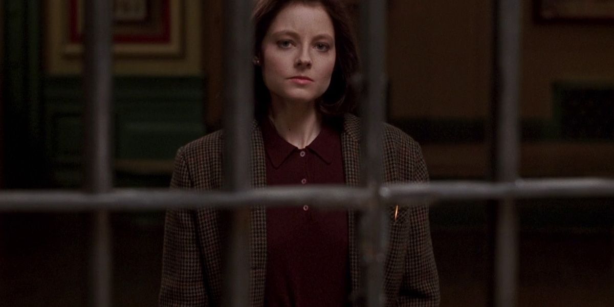 Clarice Starling (Jodie Foster) olha através das barras de cela da prisão em silêncio dos cordeiros.