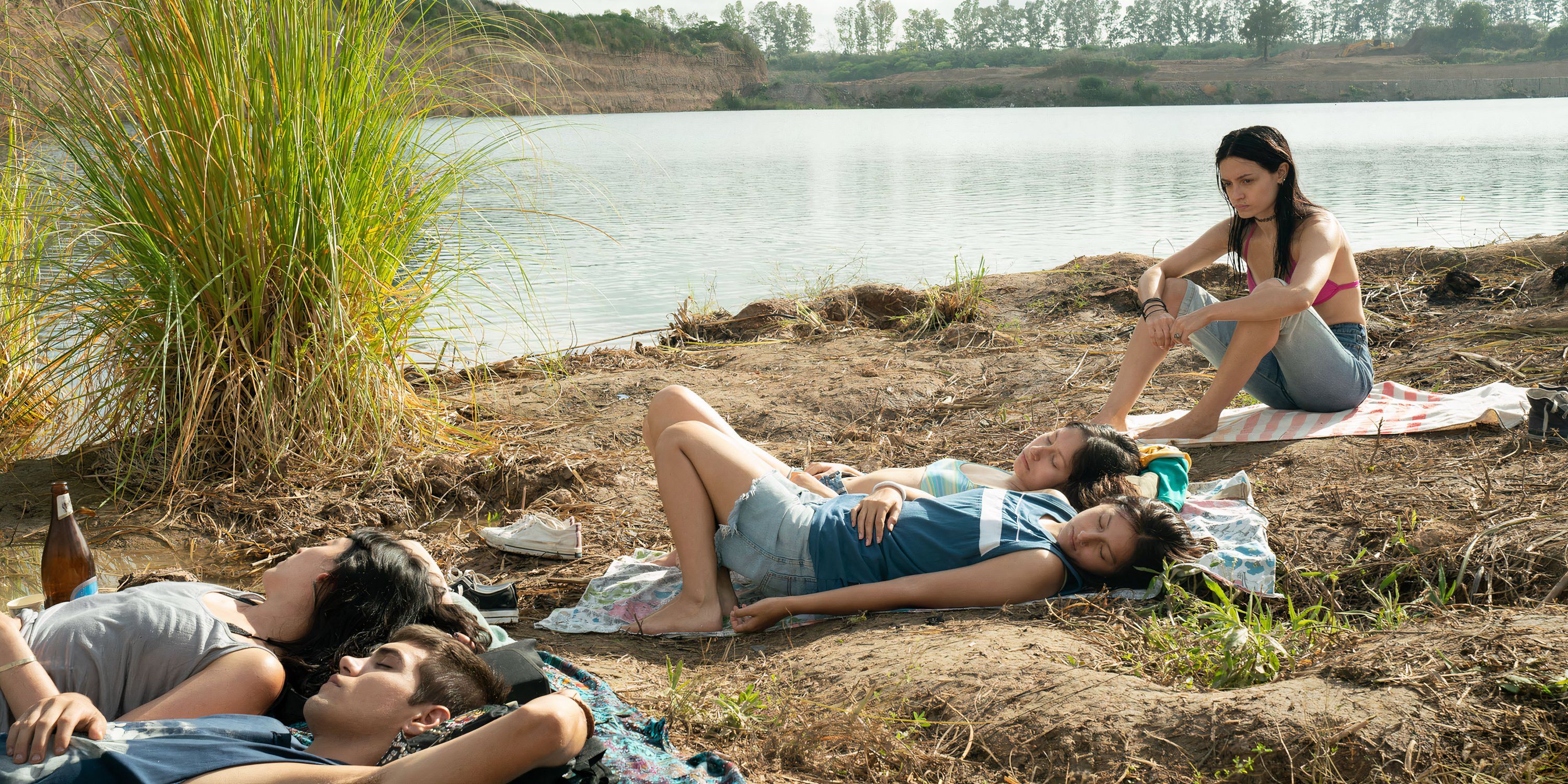 Natalia observa seus amigos tomarem banho de sol na Virgem do lago da pedreira