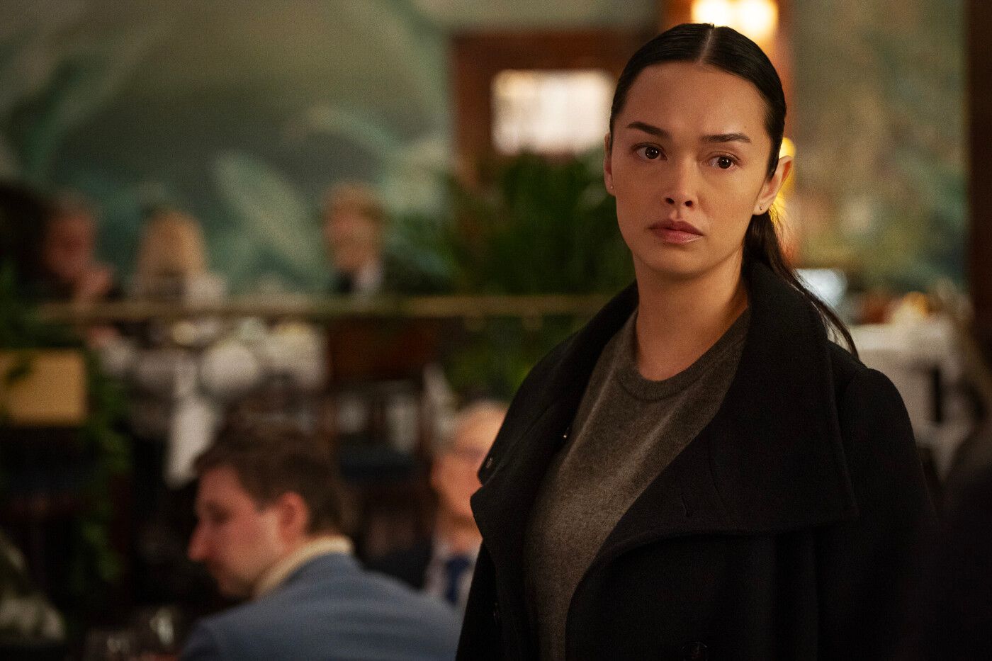 Cameron Vo, played by Vinessa Vidotto, wearing a black coat over a grey shirt in FBI: International