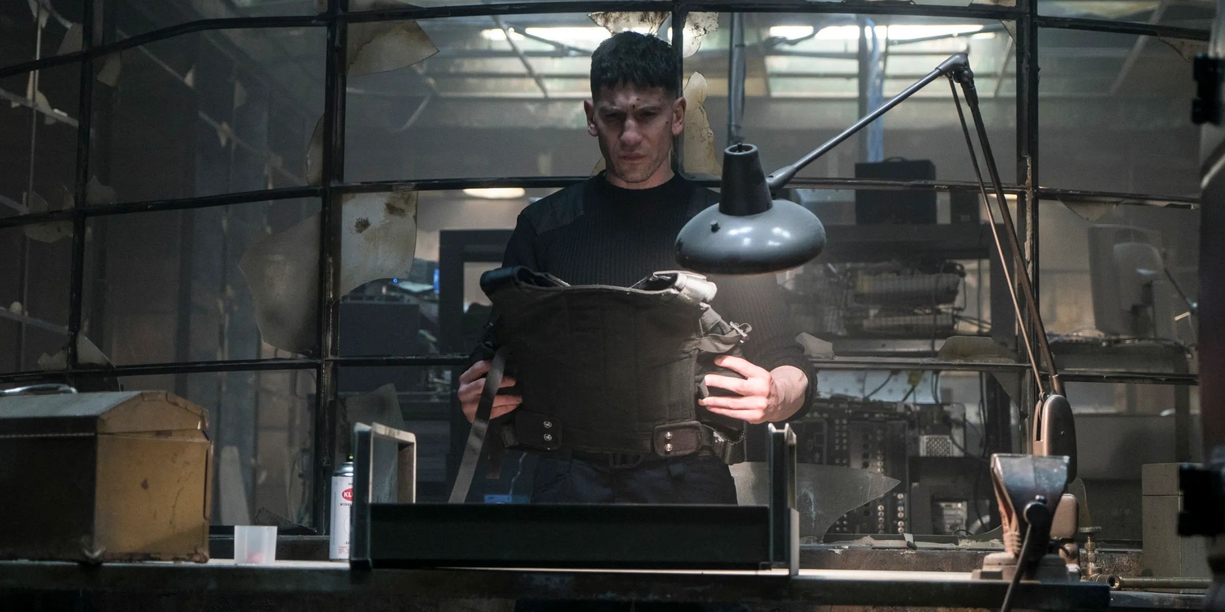 Frank Castle sosteniendo un chaleco a prueba de balas en The Punisher