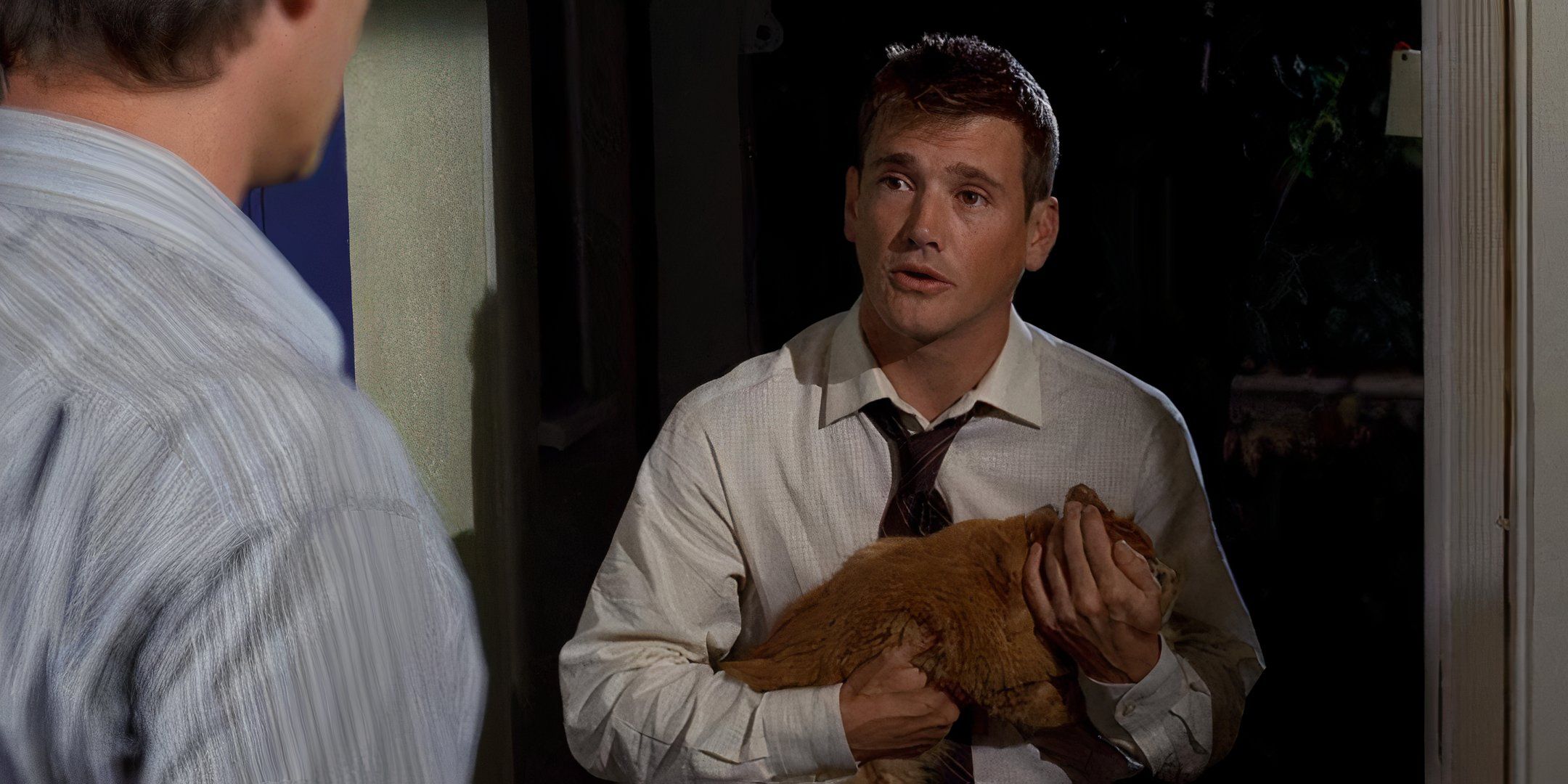 Gary de pie en la puerta de una familia sosteniendo un gato muerto en el episodio 