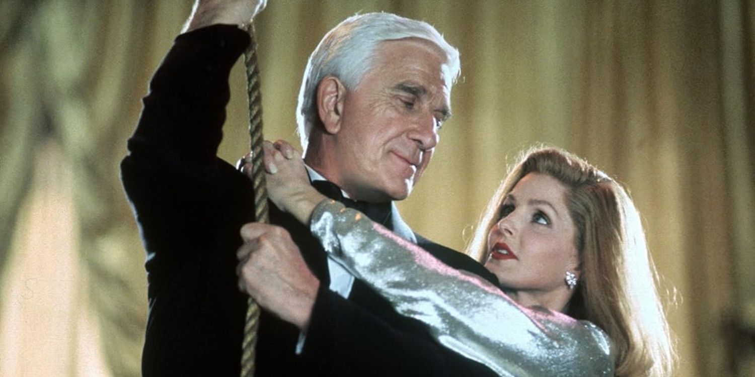 Leslie Nielsen sosteniendo una cuerda en un arma desnuda 3