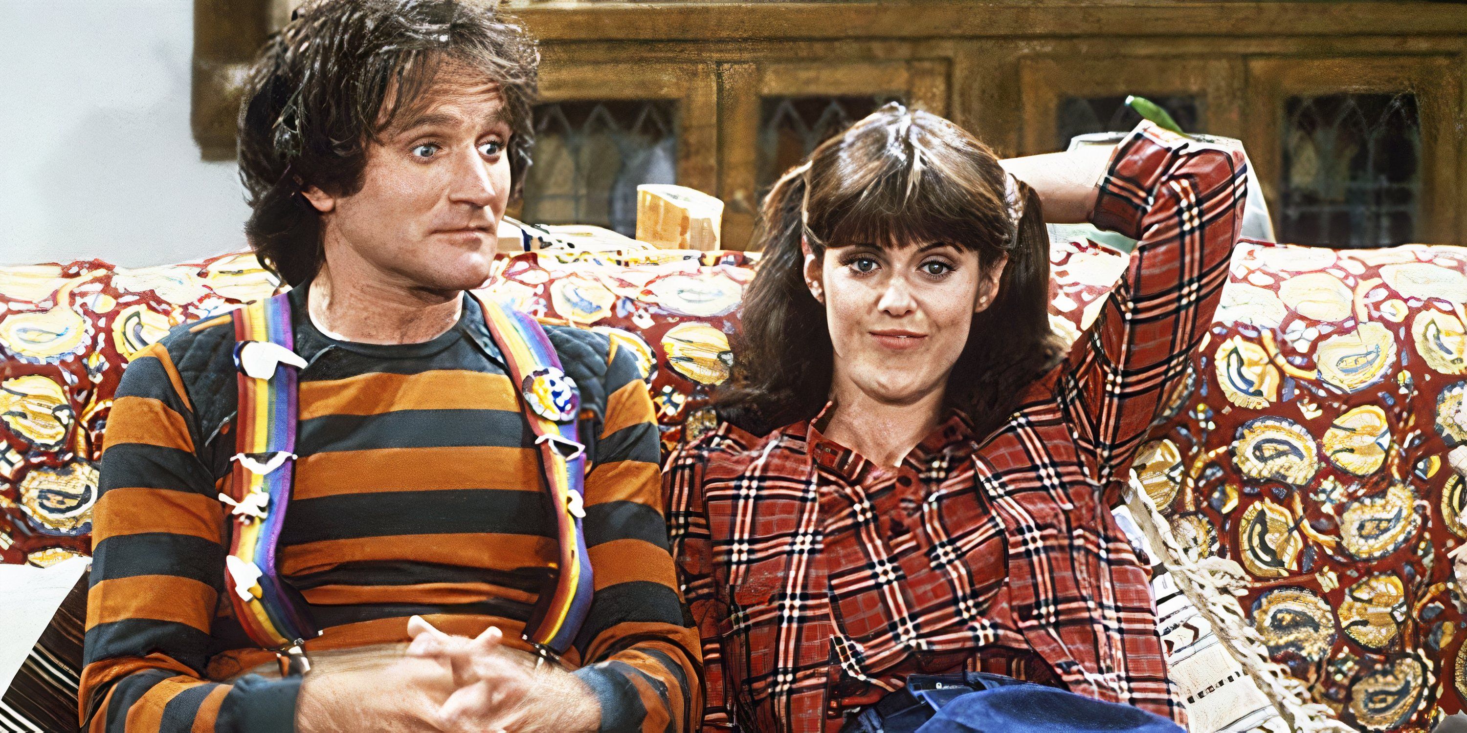 Robin Williams and Pam Dawber sit on a couch in Mork & Mindy