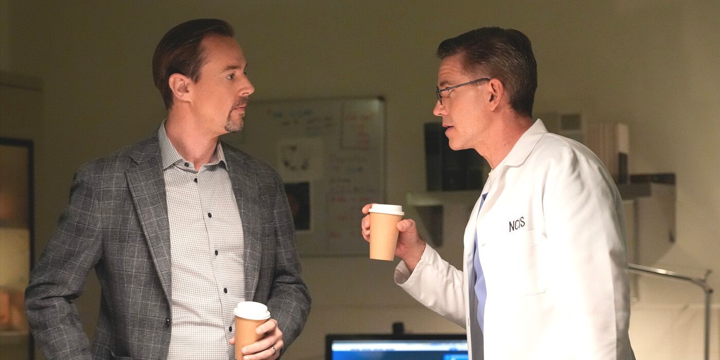 Jimmy Palmer (Brian Dietzen) NCIS'te her ikisi de kahve fincanını tutan Timothy McGee (Sean Murray) ile konuşuyor