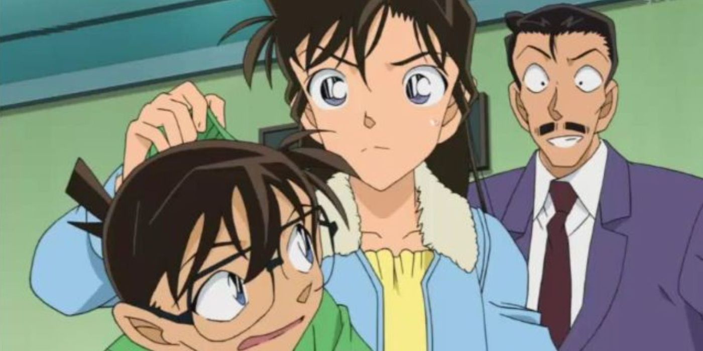 Kogoro, Dedektif Conan'daki kazakının arkasından hoşnutsuz bir Conan'ı alırken gülümsedi.