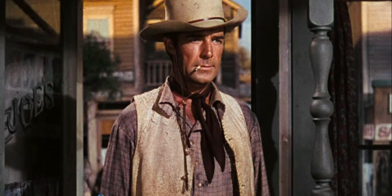 Randolph Scott, Western Union'da sigara içen bir girişte duruyor.