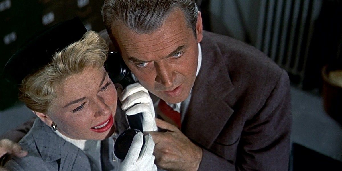 James Stewart and Doris Day hold a telephone next to each other in The Man Who Knew Too Much