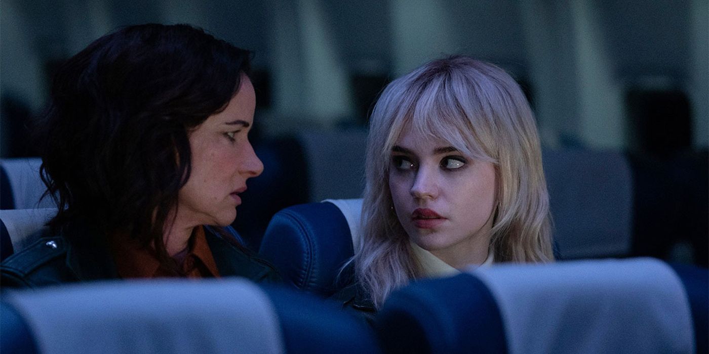 Natalie adulta y Natalie adolescente sentadas en un avión mirándose la una a la otra en Yellowjackets.