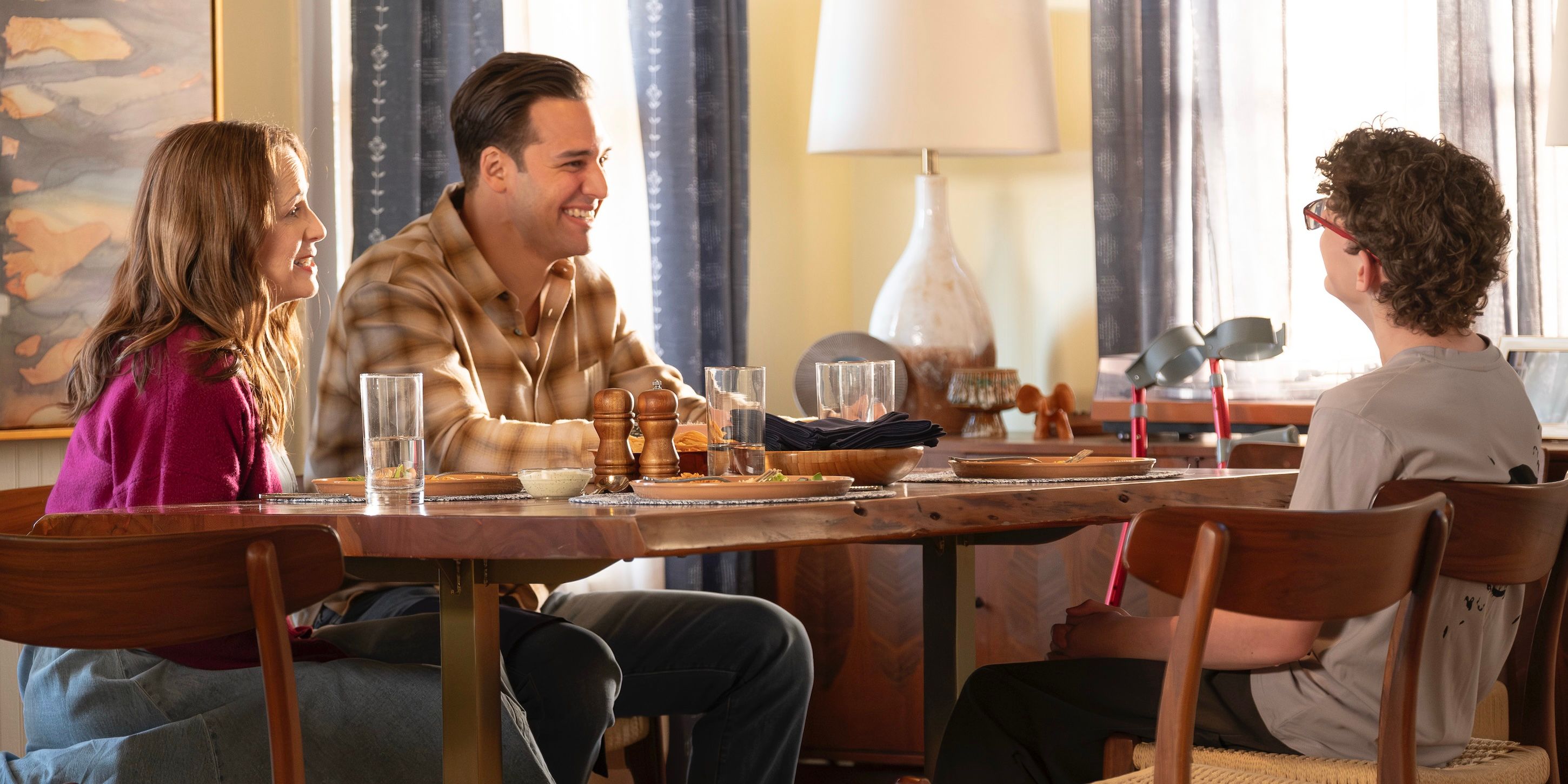 Helena Diaz (Paula Marshall) and Eddie Diaz (Ryan Guzman) talking to Christopher Diaz (Gavin McHugh) at the table on 9-1-1