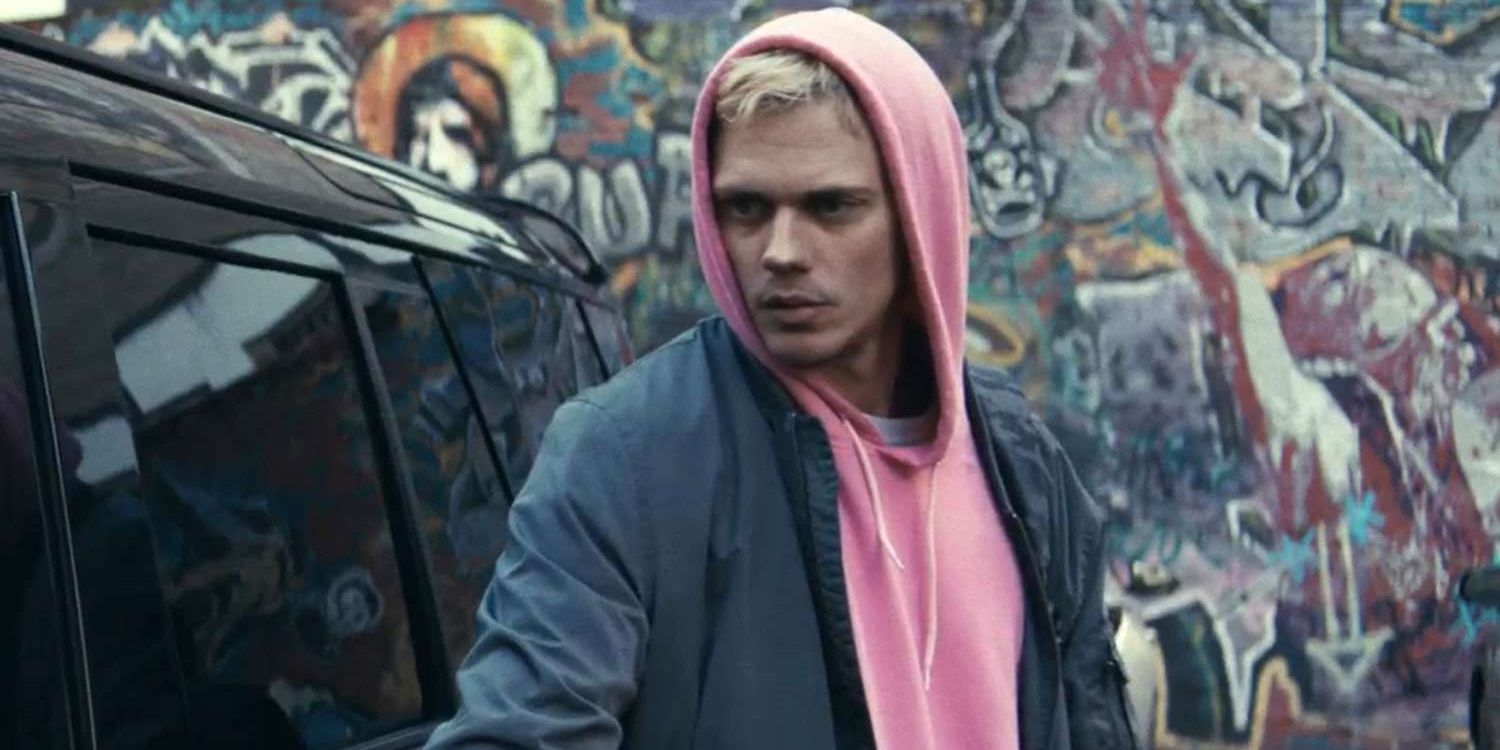 Eddie (Bill Skarsgård) de pé do lado de fora de um SUV preto trancado em um estacionamento graffitado
