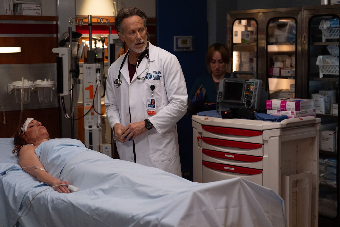 Dean Archer (Steven Weber) wearing a lab coat, standing next to Monica Pascal's body on Chicago Fire