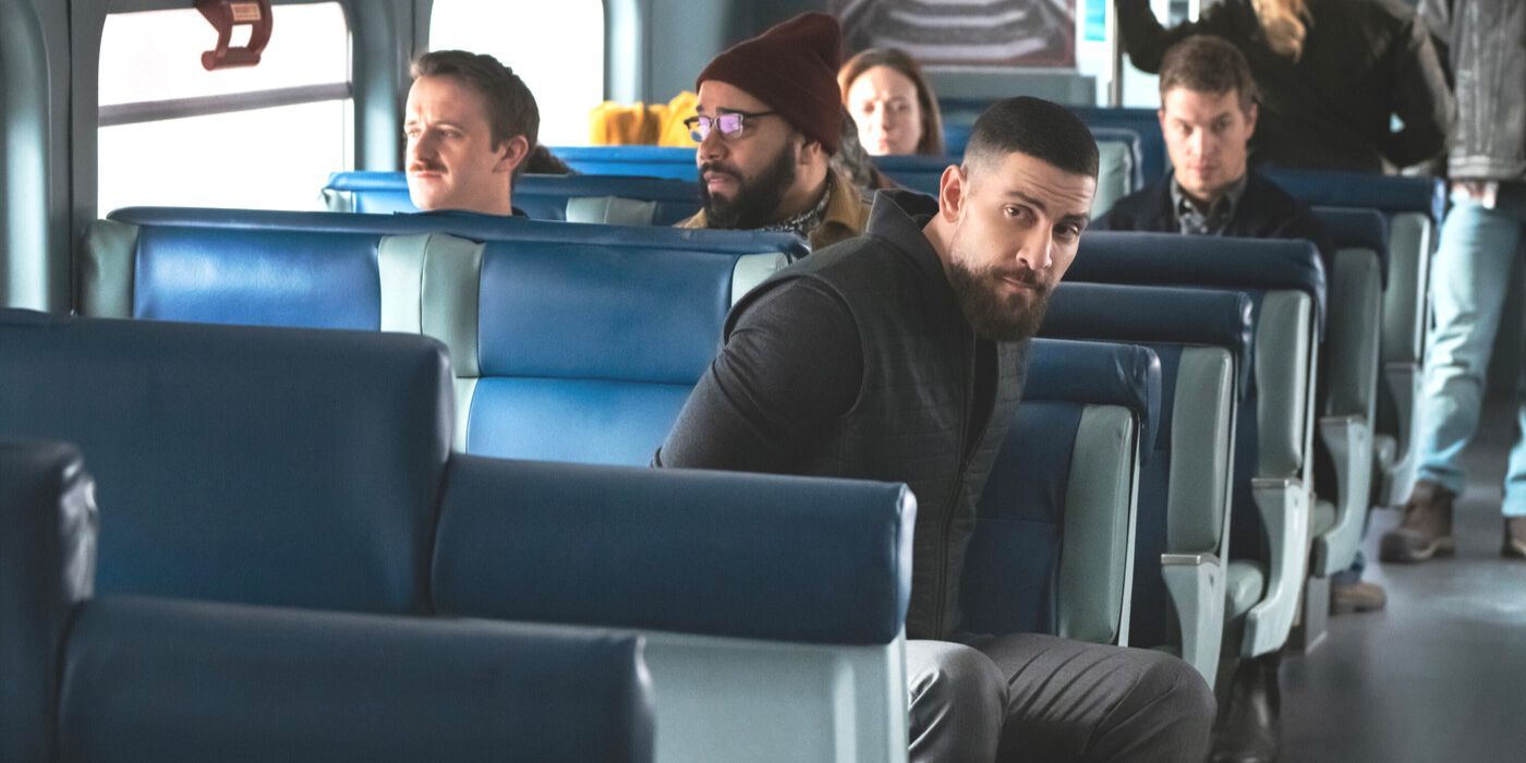 OA Zidan, played by Zeeko Zaki, wearing black jacket and looking over his shoulder on a train in FBI