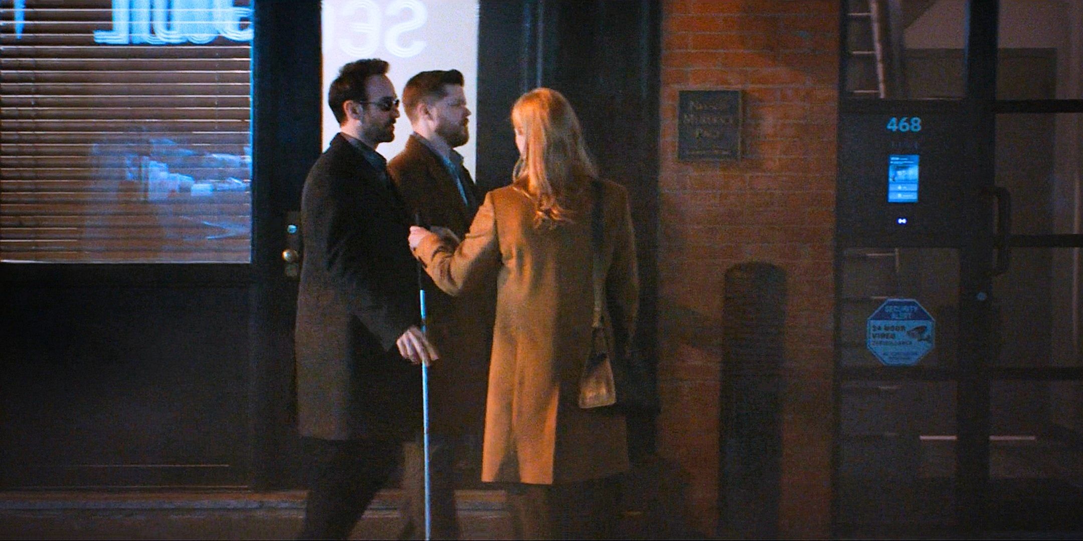 Matt Murdock, Foggy Nelson in profile, Karen Page, back to camera, outside their firm with a machine showing 468 in blue