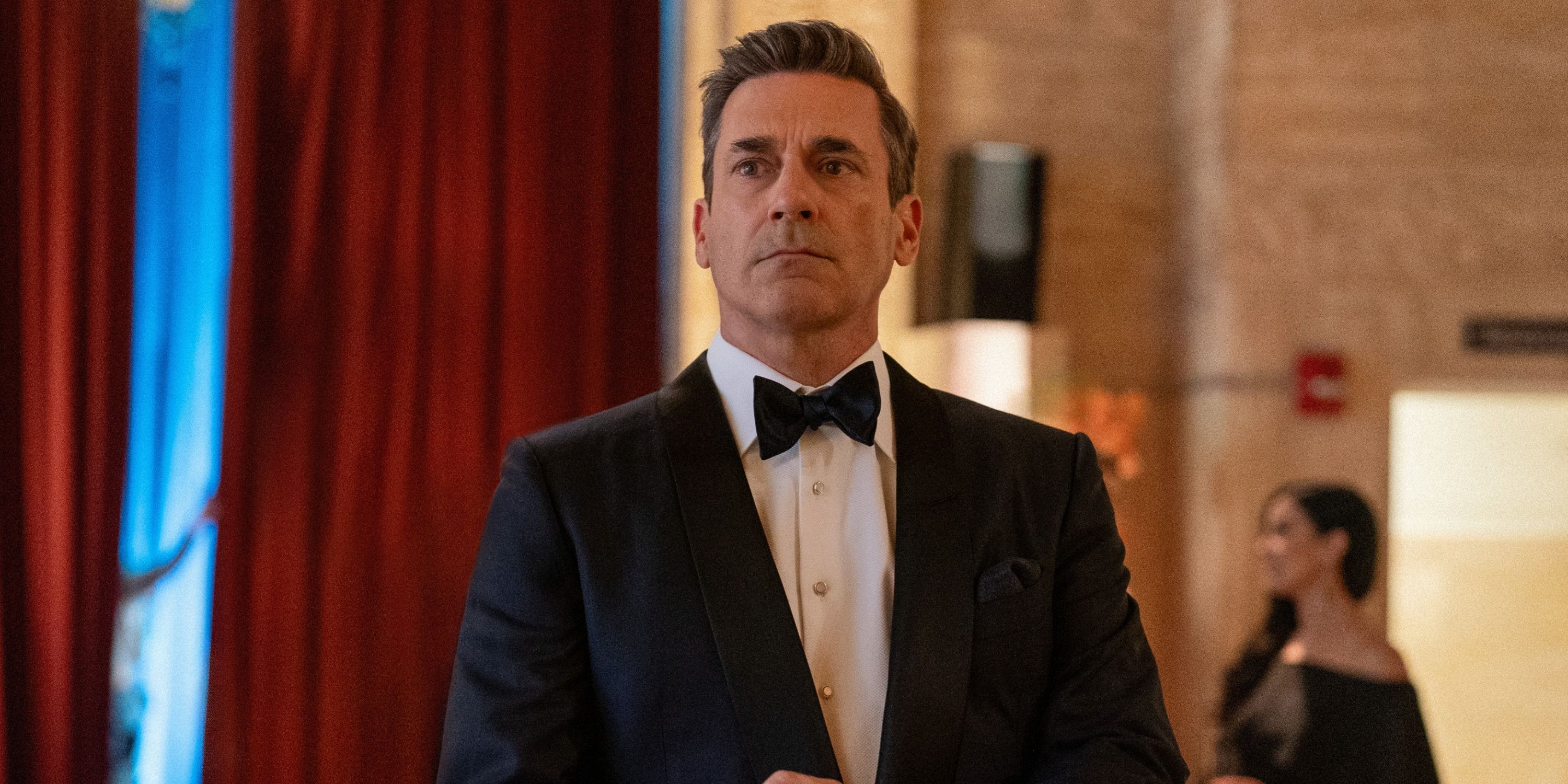 John Hamm stands in a suit in Your Friends and Neighbors