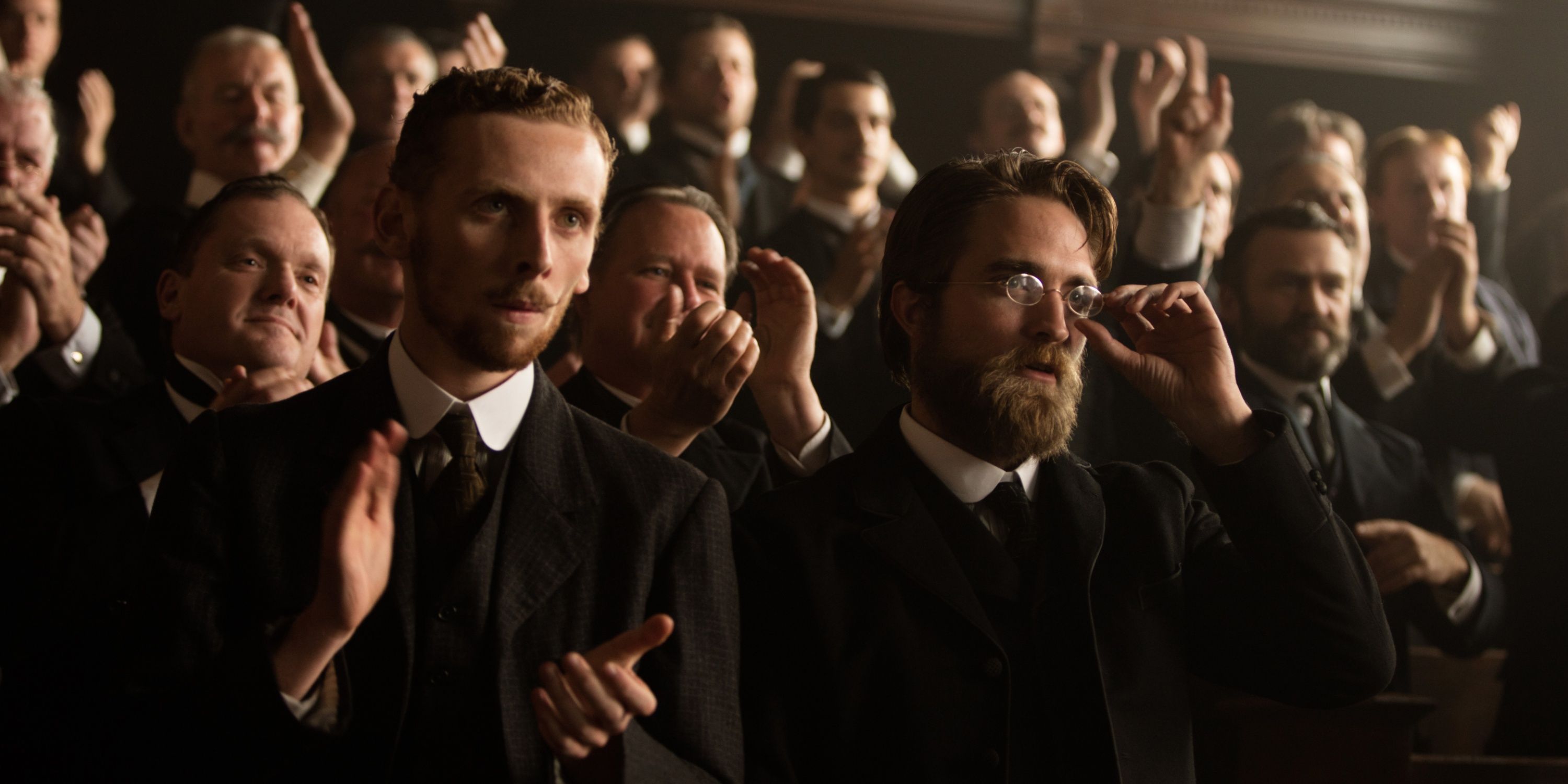 Edward Ashley and Robert Pattinson clap in The Lost City of Z