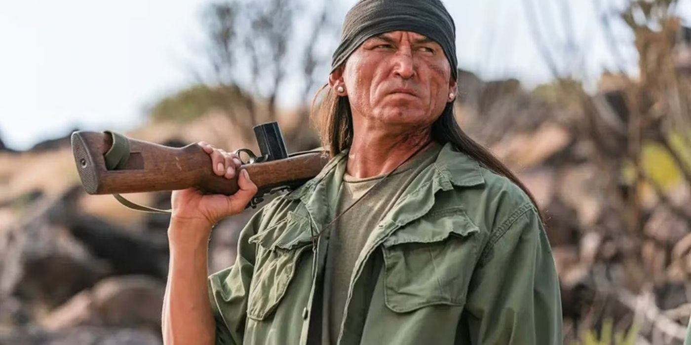 Frank Nakai com uma arma nas costas em Dark Winds