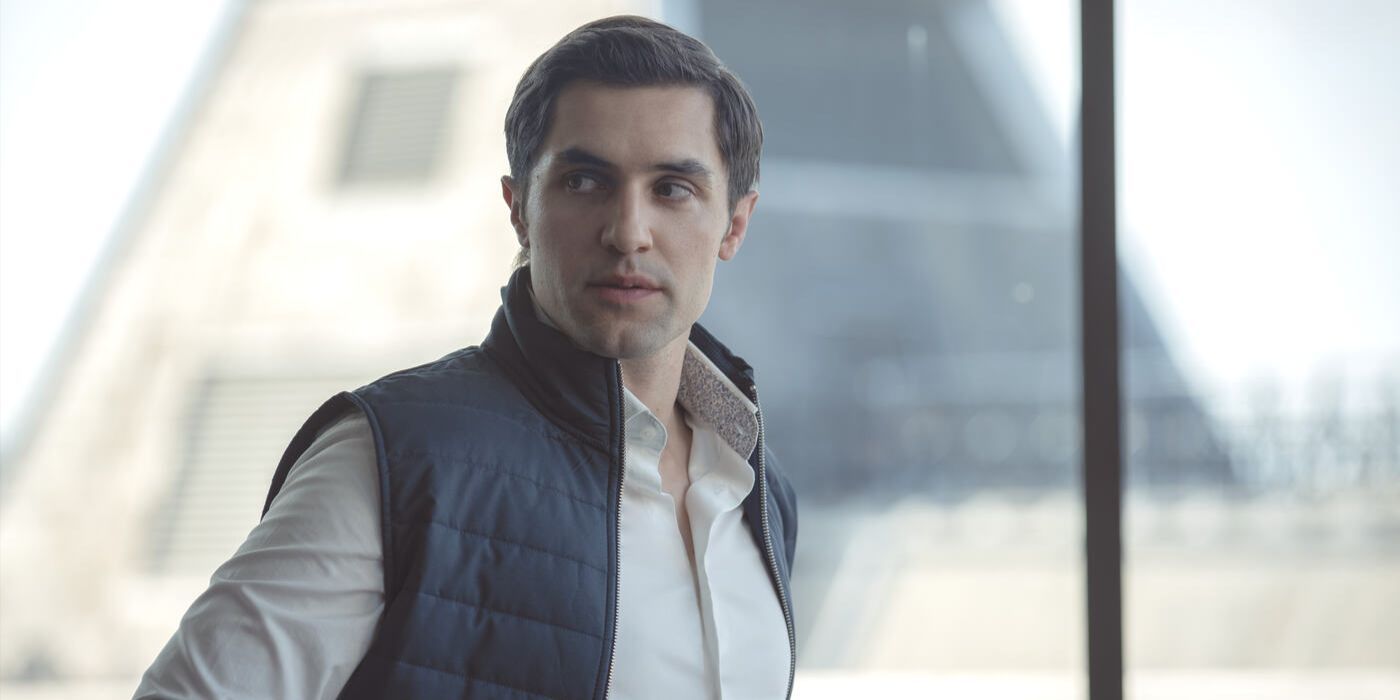 Quinn Huntley, played by Phil Dunster, wearing a blue vest and a white shirt in Apple TV + Show Surface