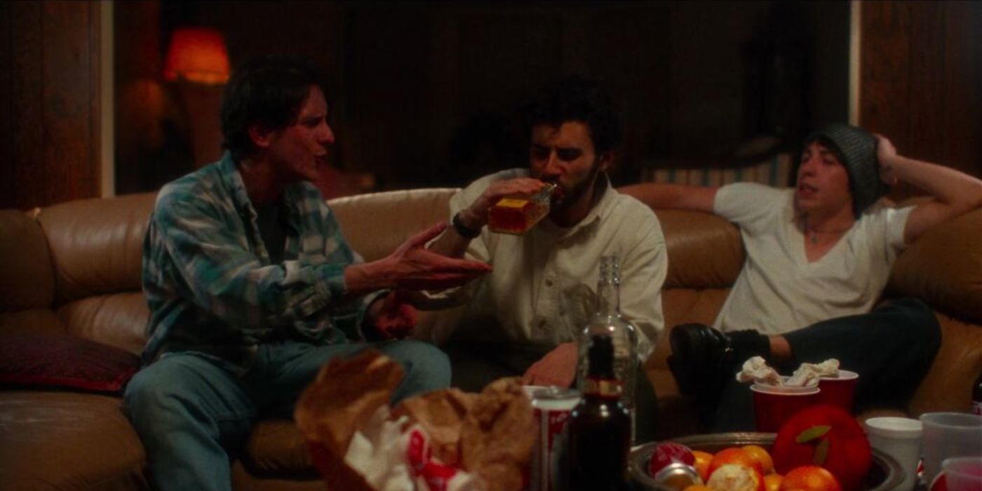 Tres amigos beben y hablan en el sofá en Four Letter Words