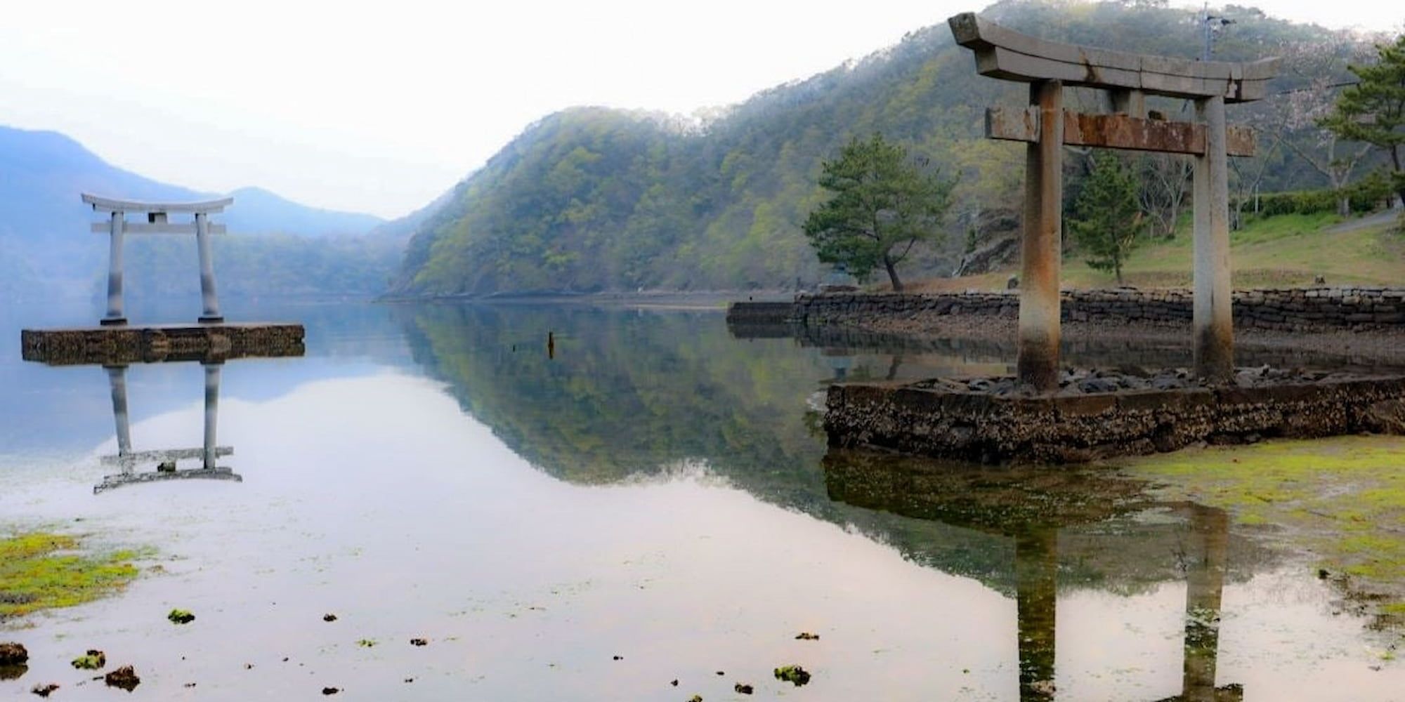 Watazumi sanctuary in front of the mountains with the reflections that shine in the water