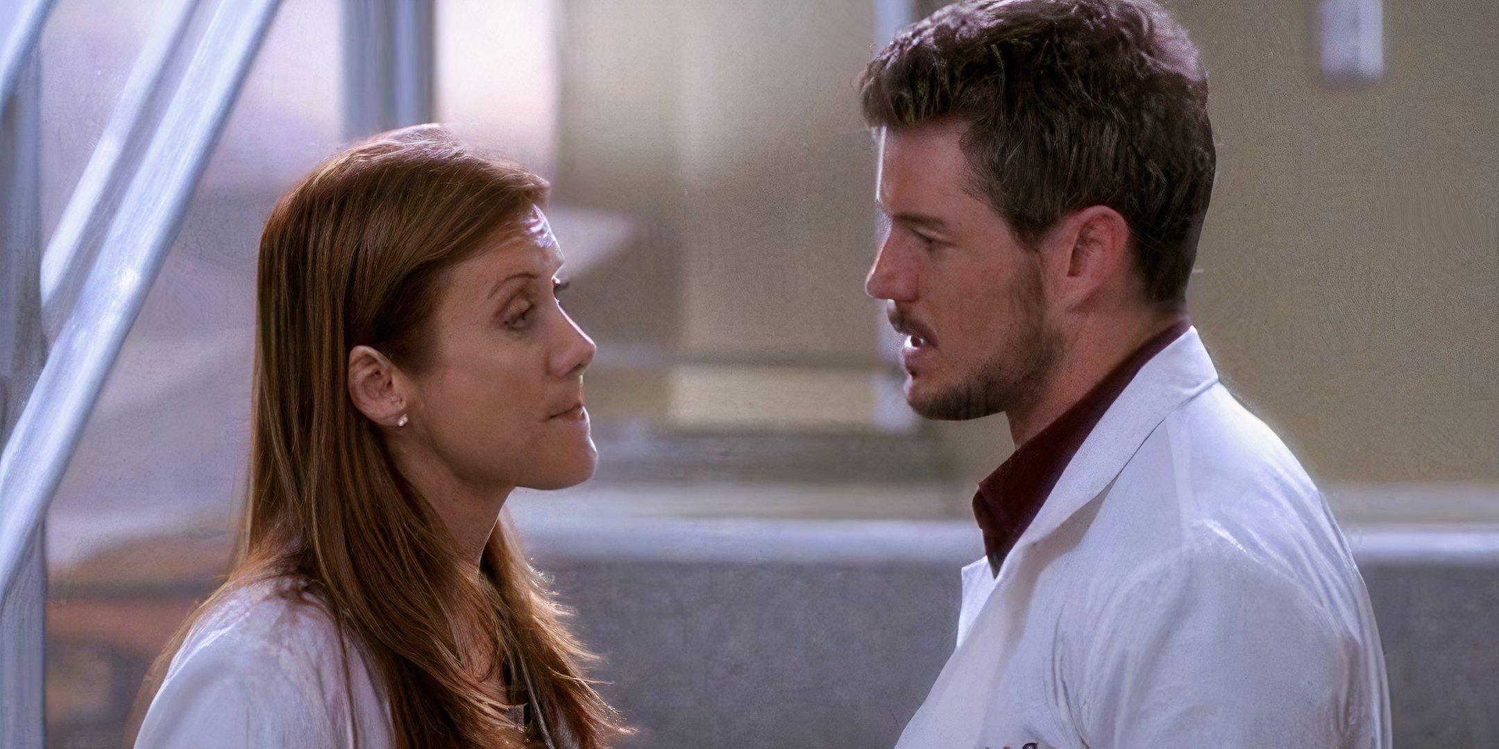 Addison Montgomery and Mark Sloan having a tense conversation in front of the stairs in Grey's Anatomy